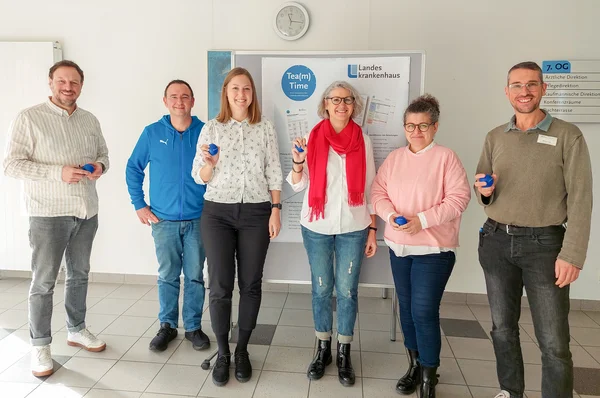 Eine Gruppe Menschen schaut in die Kamera.