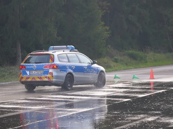 Ein Einsatzwagen der Polizei auf nasser Strecke.