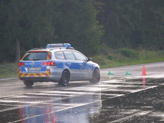 Ein Einsatzwagen der Polizei auf nasser Strecke.