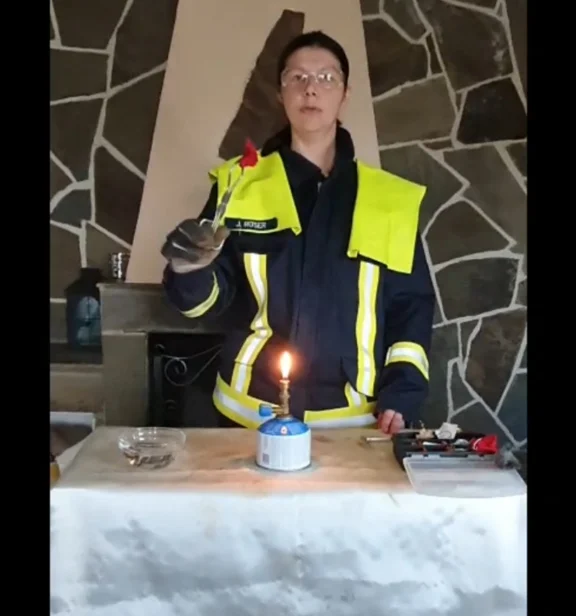 Eine Feuerwehrfrau führt ein Experiment vor.