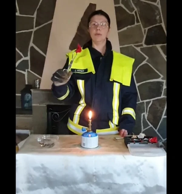 Eine Feuerwehrfrau führt ein Experiment vor.