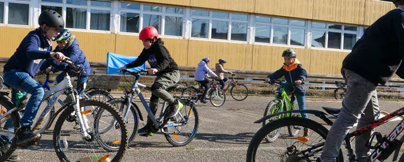Kinder fahren mit ihren Rädern im Kreis durch den Parcour.