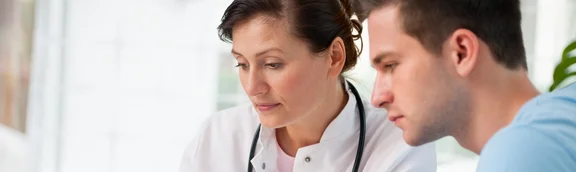 Eine Ärztin im Gespräch mit einem Patienten.