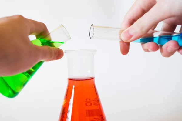 In ein Laborglas werden zwei weitere Flüssigkeiten geschüttet.