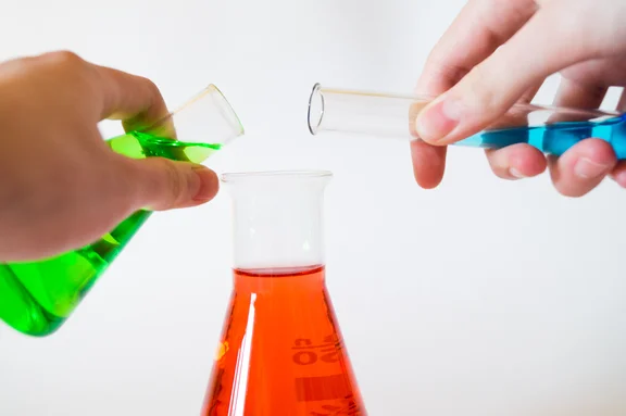 In ein Laborglas werden zwei weitere Flüssigkeiten geschüttet.