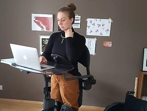 Die Autorin Sabrina Busch steht im "Easy Stand" Stehtrainer an einem Pult und arbeitet am Laptop