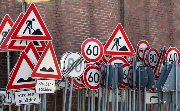 Ein Verkehrszeichen-Lager vor einer Backstein-Wand.